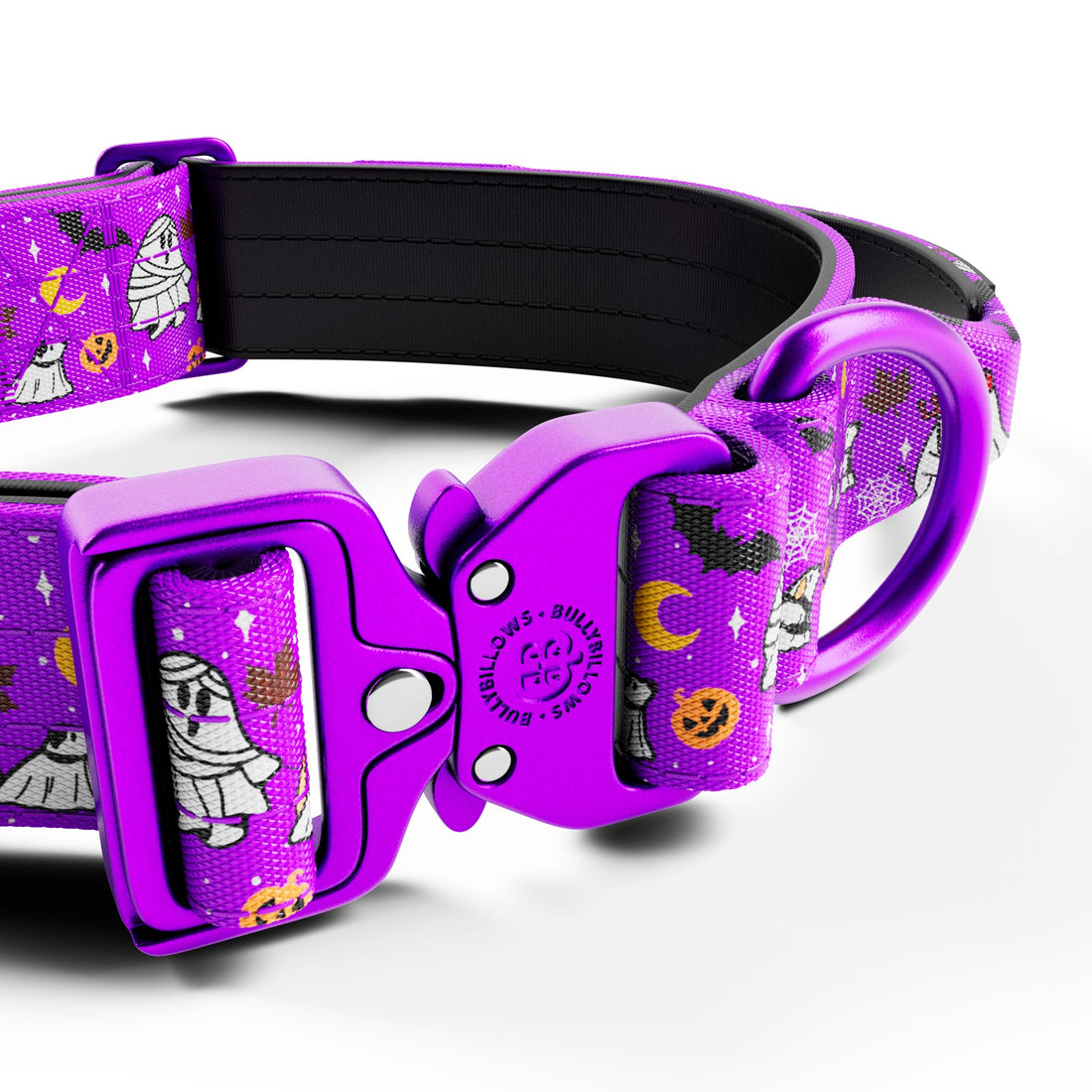 A close-up studio shot of a dog collar with a bright purple buckle and matching purple webbing printed with Halloween-themed illustrations including ghosts, pumpkins, bats, and a crescent moon. The inner lining is black.