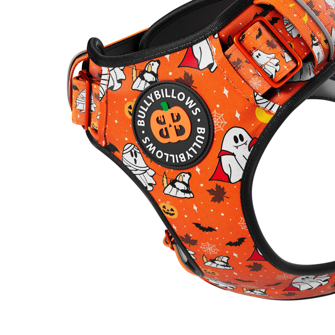 Close-up of an orange pet harness with a Halloween print featuring ghosts, mummies, pumpkins, bats, and spiderwebs. A circular black patch on the front reads 'BULLYBILLOWS' with 'BULLYBILLOW'S MOTTO' around it.